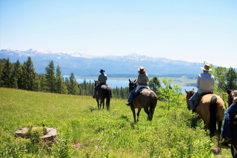 group of riders on trail ride in mountains