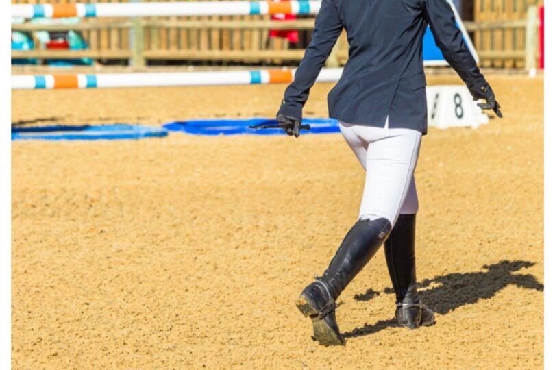 person walking a jump course